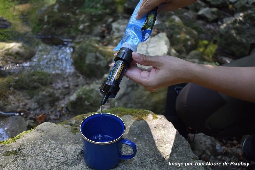 Filtre à eau de randonnée fixé sur une poche souple pour remplir une tasse.